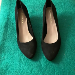 Svarta pumps i mocka-look - Stilrena svarta pumps från DS shoes by din sko med klassisk rund tå och låg klack. Skorna har en snygg mocka-liknande yta och är perfekta för dig som vill ha en tidlös och elegant look. Passar till både jeans och klänning.