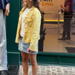 Gul jeansjacka med volangdetaljer - Snygg ljusgul jeansjacka med volang längs krage och nederkant. Jackan är i storlek s💛💛