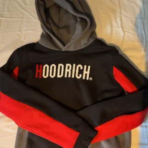Svart och röd HOODRICH hoodie - Hoodie från Hoodrich, den är i bra skick eftersom jag aldrig använder den. Den är i storlek XL i barn så skulle passa som S. Inga fläckar eller skador på tröjan. Några fler frågor får du skriva. 