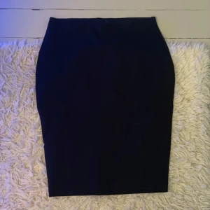 Svart pennkjol från Lindex XS - Snygg svart pennkjol från Lindex i storlek XS. Kjolen har en klassisk, tight passform och är knälång med enkel design utan mönster eller detaljer. Perfekt för dig som gillar stilrena och minimalistiska plagg.