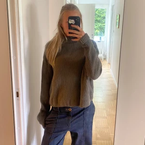 Grön ribbad stickad tröja H&M - Säljer en grön stickad tröja från H&M i ull/kashmirblandning. Tröjan har ribbad struktur, lång ärm och en lite loose passform. Perfekt för dig som gillar mjuka och sköna plagg med enkel stil. Passar till jeans eller kjol.