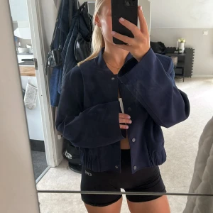 Mörkblå bomberjacka från Gina Tricot - Snygg mörkblå bomberjacka från Gina Tricot i storlek M. Jackan har en croppad passform och breda ärmar💕