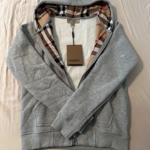 Grå burberry zip tröja - Säljer min gråa burberry zip storlek S, jätte skön och fin, håller dig varm inför vintern och är väldigt snygg