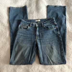 Blå bootcut jeans  - Storlek 36, se på bilder där de är lite slitna. Ena bakfickan har ett litet hål, de är från ginatricot. Mid midja.