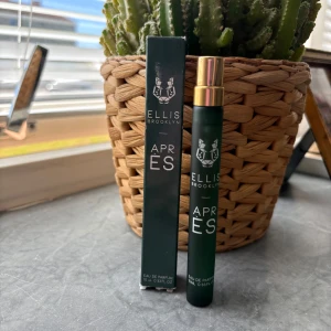 Ellis Brooklyn Après Eau de Parfum - Parfymen Ellis Brooklyn Après kommer i en smal, mörkgrön glasflaska med guldfärgad spraykork och matchande förpackning. Flaskan rymmer 10 ml och har en stilren design med vit logotyp och text. Perfekt storlek för att ta med sig i väskan. Ny