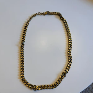 Chunky guldfärgat kedjehalsband - Säljer ett chunky halsband med breda, platta länkar i guldfärg. Kedjan har en klassisk design med justerbar längd och karbinlås. Perfekt för dig som vill ha ett statement-smycke som sticker ut och ger en cool vibe till din outfit.