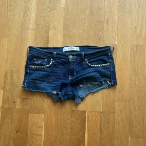 Blå jeansshorts med nitar från Hollister - Snygga blå jeansshorts från Hollister med nitar(går att ta bort),var jeans men klippte till shorts,använda fåtal gånger,skriv angående mer frågor 