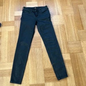 Mörkblå skinny jeans från Lee - Snygga mörkblå Lee Scarlett jeans med skinny passform och klassisk femficksdesign. Jeansen har smal siluett hela vägen ner och är tillverkade i stretchigt denim för skön komfort. Perfekt för dig som gillar en tajt look och vill ha jeans som sitter riktigt bra.