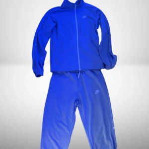 Nike Tracksuit - Snygg blå träningskostym från Nike med jacka och matchande byxor. Jackan har dragkedja framtill och diskret Nike-logga på bröstet. Byxorna har elastisk midja och logga på benet. Perfekt för dig som gillar sportig stil.