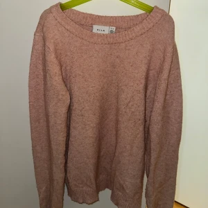 Rosa stickad tröja från VILA - Mysig rosa stickad tröja från VILA med rund hals och långa ärmar. Tröjan har ribbade muddar vid ärmslut och nederkant, perfekt för att hålla värmen under kyliga dagar. Tröjan är i bra skick och har inga större tecken på användning, nypris är 329