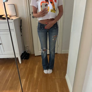 Blå bootcut jeans från Lee - Skitsnygga blå bootcut jeans med slitningar. Nyligen köpta här på plick men dom var tyvärr för små för mig så nu säljer jag vidare. Midjemått: 33,5 cm. Innebenslängd: 74,5 cm