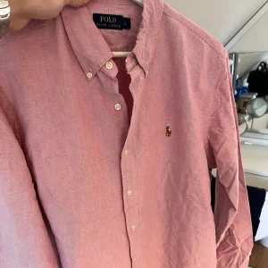 Rosa Ralph Lauren Skjorta - Rosa Ralph Lauren Skjorta i väldigt bra skick, Storlek L, ganska true to size! inga fläckar eller defekter.