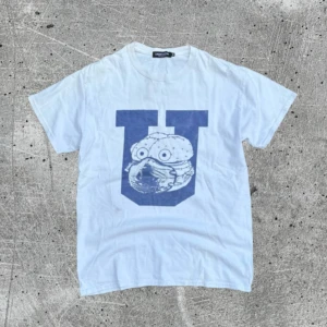 Vit t-shirt Undercover med U-print - tvärfet undercover tee. tyvärr lite fläckar på den från förra ägare. har inte försökt ta bort dem. kontakta för mer info.