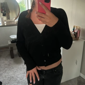 Svart kofta från Selected Femme - Svart, mjuk kofta från Selected Femme i storlek S. Koftan har v-ringning, långa ärmar och knappar framtill. Den är ribbad vid muddar och nederkant. Inte andvänd mycke💗💗