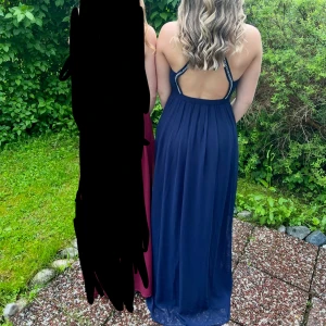 Marinblå långklänning från Nelly eve - Säljer en marinblå långklänning från Nelly eve i storlek 32. Klänningen har öppen rygg och smala axelband dekorerade med pärlor och glittrande stenar. Materialet är mjukt och faller snyggt och detsuttom med slits, perfekt för bal eller student. Lite skavanker vid pärlorna men inget som syns.✨✨