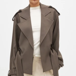 Beige trenchcoat med bälte - Säljer min slutsålda trenchcoat från NAKD. Säljer då jag har andra jackor som jag använder mer. Har bara haft på mig den några få gånger. Köpt för 1100kr