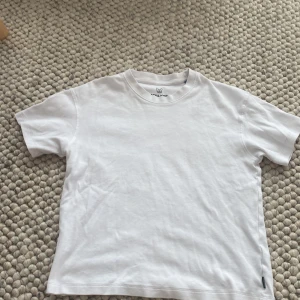 Vit t-shirt från Jack & Jones - En clean vit t-shirt från Jack & Jones med rund hals och korta ärmar. T-shirten är gjord i mjuk bomull och har en enkel, klassisk passform. Perfekt för chill dagar och enkel att matcha med jeans eller shorts.