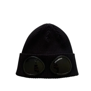 Svart ribbad mössa C.P. Company - Svart ribbstickad mössa från C.P. Company med coola inbyggda svarta glasögon framtill. Mössan har uppvikt kant och en urban vibe som sticker ut. Perfekt för dig som vill ha något unikt och trendigt på huvudet.