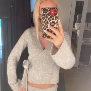 Grå omlottkofta från Gina Tricot - Mysig grå omlott kofta med knyt i sidan och v-ringad hals. Den är från Gina i storlek s . Slutsålda i xs, s & M på hemsidan..🩷 Använd 3 gånger . Skriv om ni vill ha fler bilder så fixar jag🩷