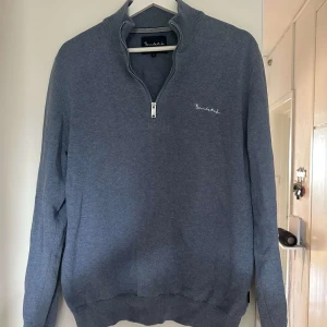 Blå half zip tröja från Bondelid - Snygg blå tröja från Bondelid med half zip och ståkrage. Tröjan har långärmade ärmar och ett litet broderat Bondelid-logo på bröstet. Storlek small. Defekt på baksidan 