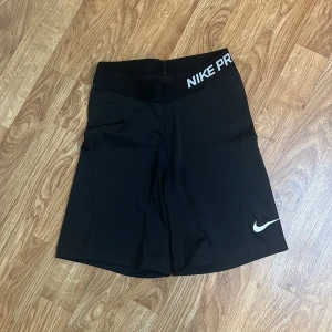 Nike Pro svarta träningsshorts XS - Nike Pro svarta shorts med elastisk midja och vit logga på benet. Tight passform och tillverkade i Dri-FIT. Storlek XS. Använda fåtal gånger. 