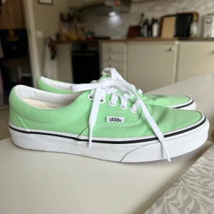 Gröna sneakers från Vans - Snygga gröna sneakers från Vans med vit sula och klassisk snörning. Perfekta för en avslappnad stil och ger en färgklick till din outfit. De har en låg profil och är bekväma att bära hela dagen.