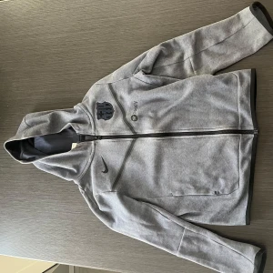 Äkta Barcelona tech fleece nike - Säljer min sjukt snygga Barcelona tech fleece, Nike i mycket bra skick! Storlek 147-158(12-13 år). Kan vara lite lite nopprig på ett ställe men syns inte! Kom gärna med frågor. Sällsynt tröja du inte hittar billigare!