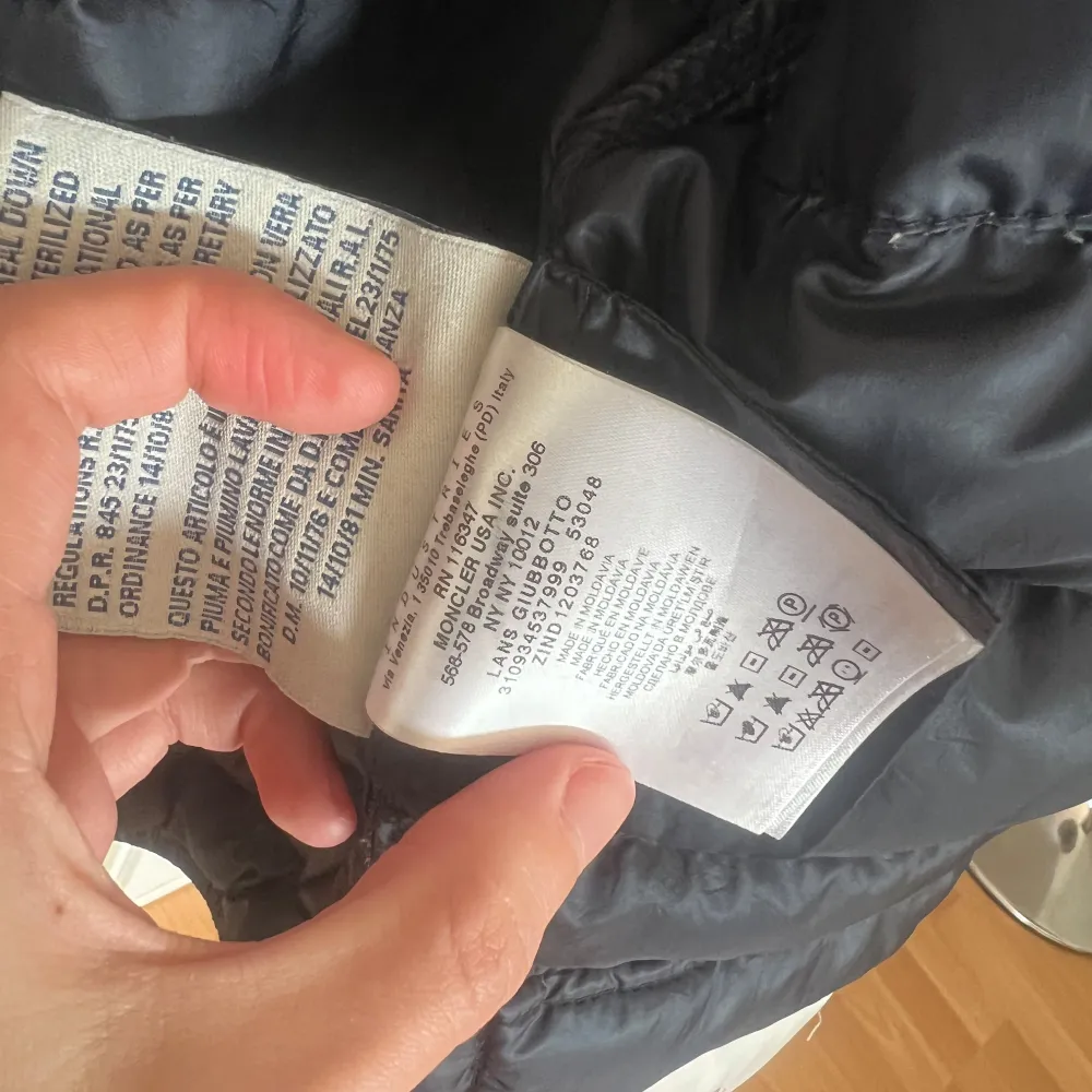Snygg svart dunjacka från Moncler med dragkedja och två fickor framtill. Jackan har en quiltad design och en hög krage för extra värme. Perfekt för kyliga dagar. Finns tecken på användning - ett igensytt hål på rygg + inuti jackan som knappt syns. Nyss kemtvättad & lagat dragkedjan hos skräddare. Storlek 1. Takit.