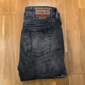 Grå jeans från Diesel - Snygga grå bootcut jeans från Diesel, modellen 1969 D-Ebbey. Dom är lite ljusare i verkligheten. Köpta för 1800kr inga defekter. Säljer då de är för små för mig. Pris kan diskuteras