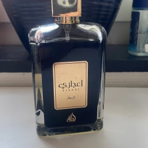 Lattafa Ejaazi Efp 100ml - Säljer en elegant Ejaazi Eau de Parfum från Ard Al Zaafaran. Flaskan är stilren med en mörk design och guldfärgad etikett. Perfekt för den som söker en unik och lyxig doftupplevelse. Tillverkad i U.A.E. Mer än 90ml kvar