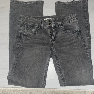 Grå bootcut jeans - Snygga grå jeans från Gina Tricot med klassisk femficksdesign och knappgylf. De är Low Waits och bootcut. Pris går alltid att diskutera 💗
