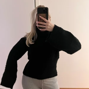 Svart fluffig polotröja - Mysig svart polotröja med en fluffig textur. Tröjan har långa ärmar och en hög polokrage. Knappt använd. Från Bikbok i storlek XS. Köparen står för frakten. 🩷