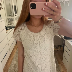 Vit spetsblus från ONLY !! - Säljer en söt vit spetsblus från ONLY med korta ärmar och ett vackert blommönster. Perfekt för en stilren och romantisk look. Blusen har en rund halsringning och är i ett mjukt material. Storlek S! 💞🌷