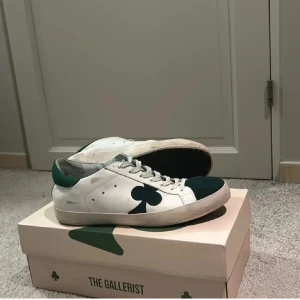  The Gallerist skor - Snygga sneakers från The Galarist, med gröna detaljer och en unik klöverdesign på sidan. Skorna har snörning och en bekväm sula. Perfekta för en stilren look. Tar även emot byten… ♣️♣️♣️