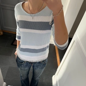 Blå stickad tröja  - Blå randig trekvartsärmad stickad tröja från Together i fint skick. Kan inte hitta storlek men skulle säga s/m. Använd gärna köp nu!