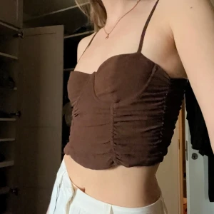 Brun korsettopp - Justerbara axelband, dold dragkedja i sidan, stretchig, faktisk underwire. Använd en del men i bra skick, köpt på Bershka