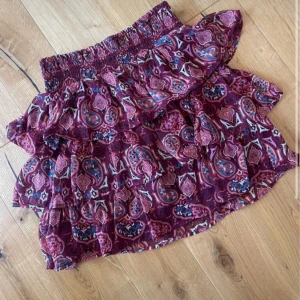 Mönstrad volangkjol i vinrött - En kjol från Lindex, storlek 170 vilket motsvarar cirka S😇köpt från plick innan men har inte kommit till någon användning 