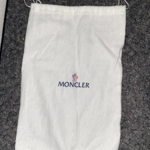 Svarta sneakers från Moncler - Snygga svarta sneakers från Moncler med vita sulor och Moncler-logga i rött och vitt på sidan. Skorna har snörning och en stilren design som passar perfekt för en trendig look.