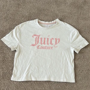 Vit t-shirt från Juicy Couture - Säljer en vit t-shirt från Juicy Couture med rosa logotyp på framsidan. T-shirten har en normal passform och korta ärmar. Knappt använd. Säljer pga att den har blivit för liten för mig💖