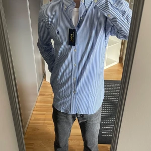 Blå och vit randig skjorta från Ralph Lauren - Helt ny skjorta från ralph lauren i storlek M. Köptes på Ekbergs i Kristianstad och nypris är 1795kr. Jag är 178 och väger 73kg som referens. Skriv bara om du har någon fråga :)