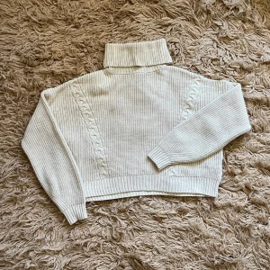 Beige stickad polotröja - Beige stickad polotröja med kabelstickade detaljer. I fint skick.