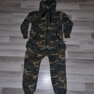 Camouflage onepiece från Oneswe Jumper - Säljer en cool camouflage onepiece från Oneswe Jumper. Den har en dragkedja framtill och en mysig huva. Materialet är bomull, vilket gör den både bekväm och hållbar. Perfekt för att chilla hemma eller hänga med vänner. 🐾 väldigt sparsamt använd, så gott som ny.