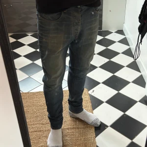 Blå jeansbyxor - Snygga blå jeans med en klassisk femficksdesign och lätt slitna detaljer. De har en knappgylf och är perfekta för en avslappnad stil. Passformen är smal och de är tillverkade i ett bekvämt denimtyg. Från märket the blue uniform! Straight/slim fit