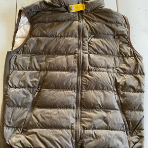 Mörk grön dunväst från Parajumpers - Säljer en mörk grön dunväst från Parajumpers. Den har några fläckar på insidan av västen. Har inte kvitto till den 