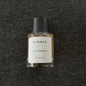 Essnce Hot Mimosa Eau de Parfum - Säljer en flaska Essnce Hot Mimosa Eau de Parfum. Flaskan är genomskinlig med en svart kork och har en stilren etikett. Perfekt för dig som älskar en varm och blommig doft. Ytterst taget några milliliter, se bild. Skulle gissa på 40ml kvar