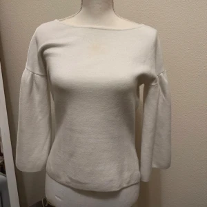 Vit tröja med trekvartsärm - Säljer en stilren vit tröja med trekvartsärm. Perfekt för en minimalistisk look och passar bra till både jeans och kjol. Tröjan har en enkel design med rund hals och är tillverkad i ett mjukt material.