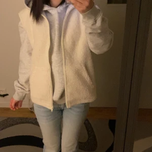Vit fleeceväst med dragkedja - Säljer en mysig vit fleeceväst med dragkedja framtill. Använd 5/6 gånger utan några deftketer, säljer då den intr kommer till användning och är lite för stor