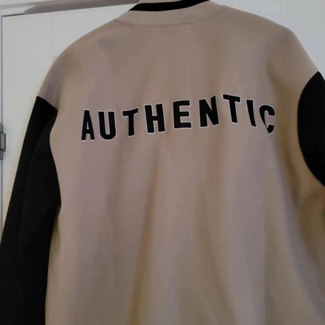 Beige och svart bomberjacka med text - 1