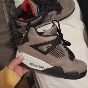 Nike Air Jordans i mocka och svart - Snygga Nike Air Jordans i en kombination av brun mocka och svarta detaljer. Skorna har en vit sula med synlig luftdämpning och svarta snören. Perfekta för en stilren look med en touch av sportig elegans.