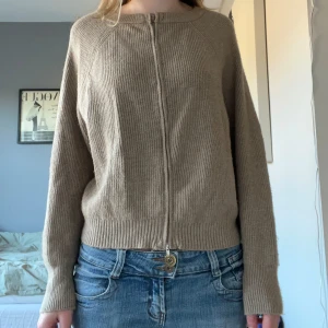 Beige ribbad kofta med dragkedja - Superfin stickad kofta med två dragkedjor! Står ingen storlek i men skulle säga att den är s-m